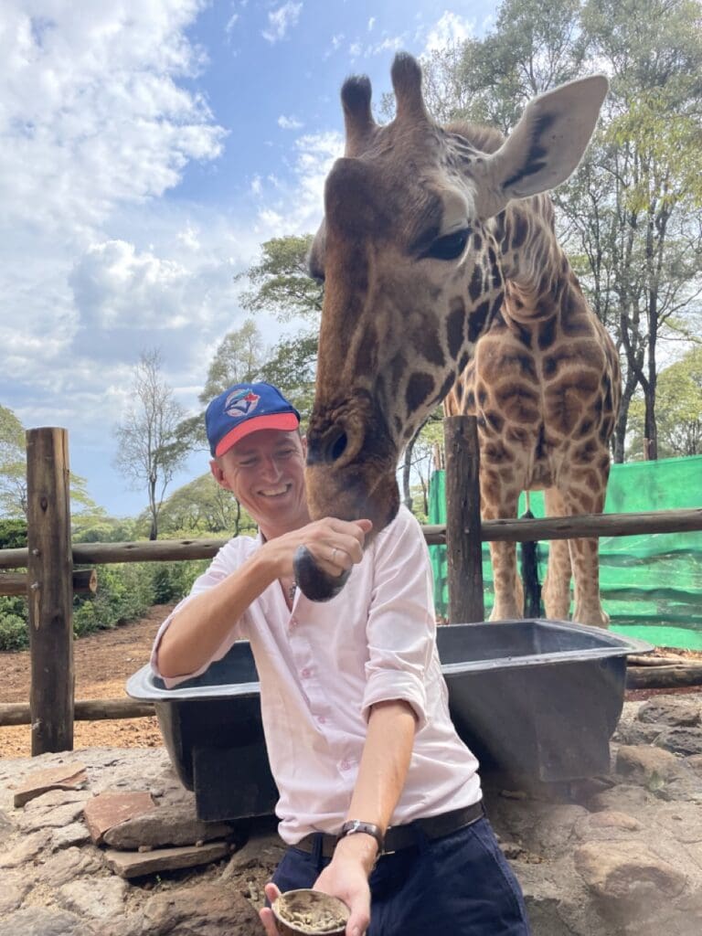 Ladislas feeding a giraffe after exploring the Nairobi real estate market